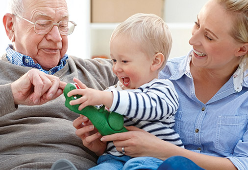 Assisted Living grandparents with grandchild smiling and playing